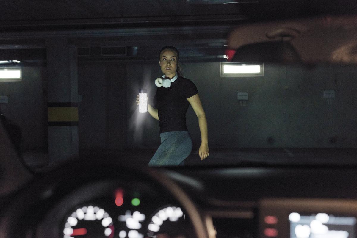 Läuferin im Dunkeln mit der reflektierenden Thermosflasche von Magisso