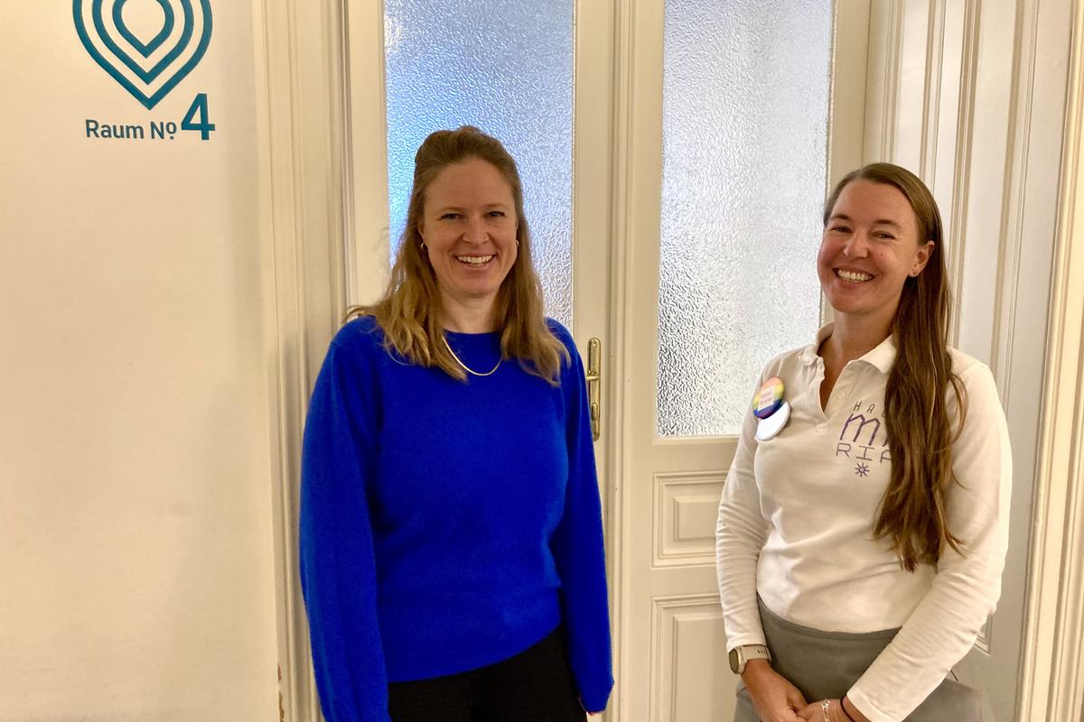 Bild von Miriam Alvarado von der an.doc.stelle und Ines Werzinger von der Marien Apotheke, die vor einem Raum mit Glastür stehen. An der Wand steht links daneben "Room no 4".