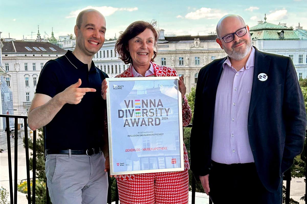 Sreco Dolanc, Karin Simonitsch und Wien Museums-Direktr Matti Bunzl stehen auf der Terrasse des Wien Museums. Karin Simonitsch hält die Auszeichnung "Vienna Diversity Award" in Händen.