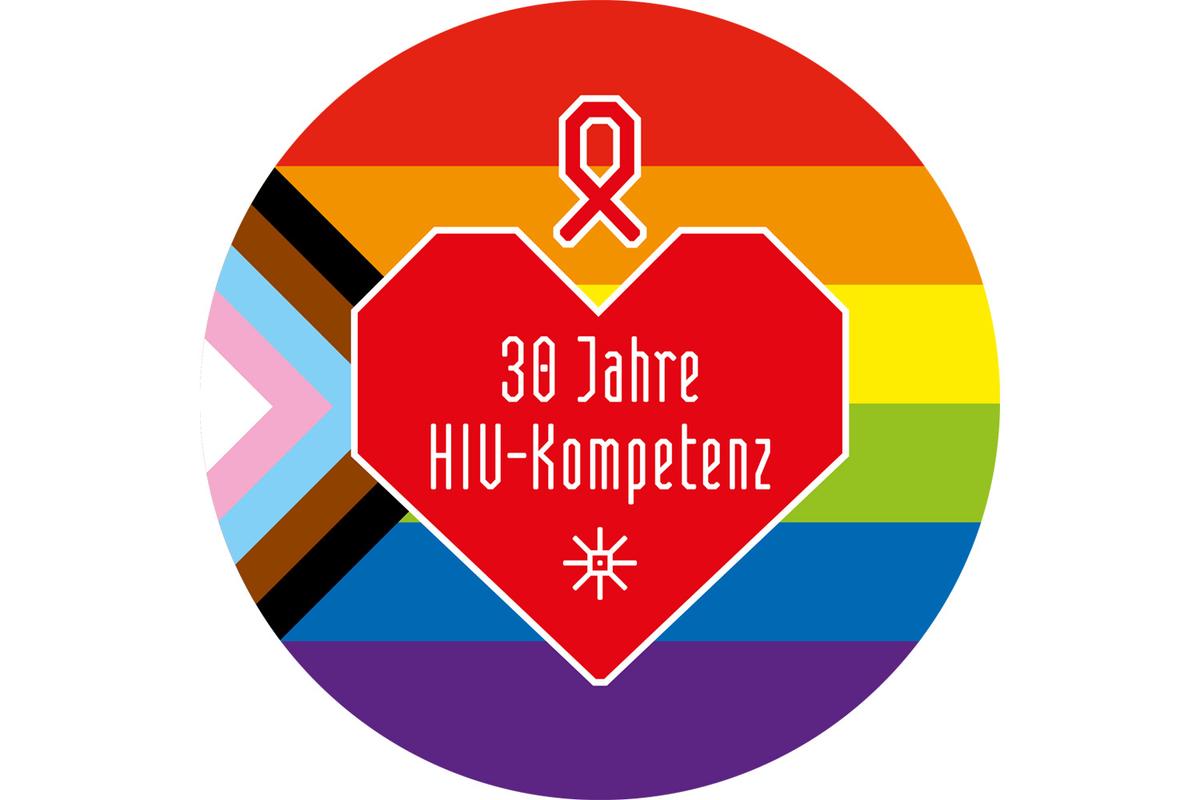 Rundes Logo mit progressiver Regenbogenflagge und rotem Herz in der Mitte. Darin steht "30 Jahre HIV-Kompetenz". Darüber ist ein Red Ribbon zu sehen.