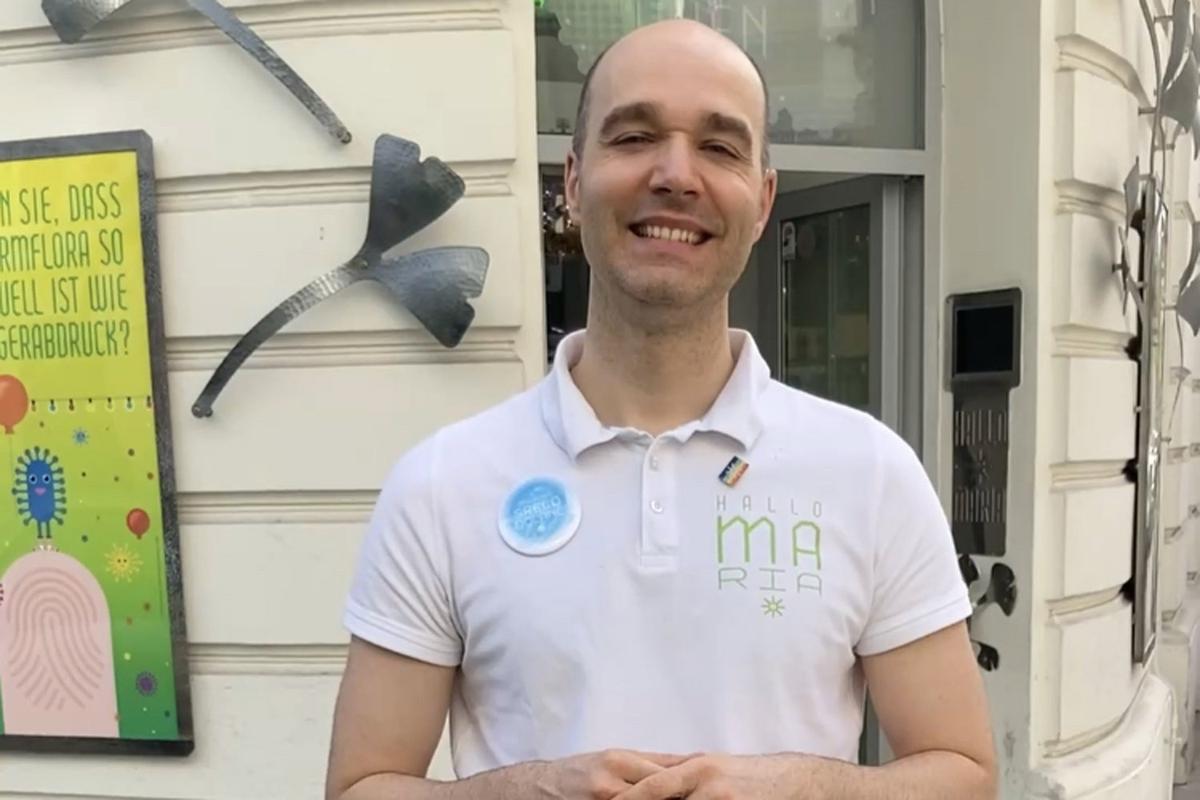 Mag. Sreco Dolanc steht im kurzen weißen T-Shirt vor dem Eingang der Marien Apotheke.