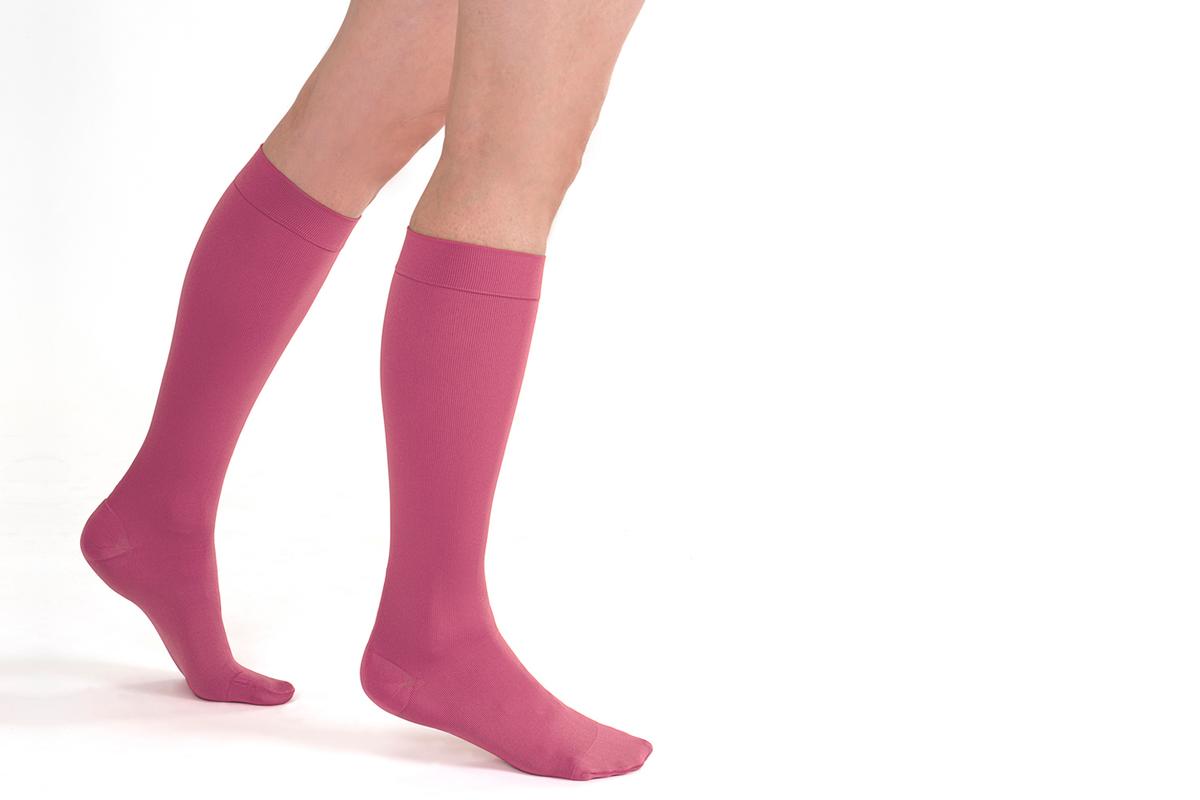Beine mit Stützstrümpfen von SkySocks in berry. Die Beine sind bis zum Knie zu sehen.