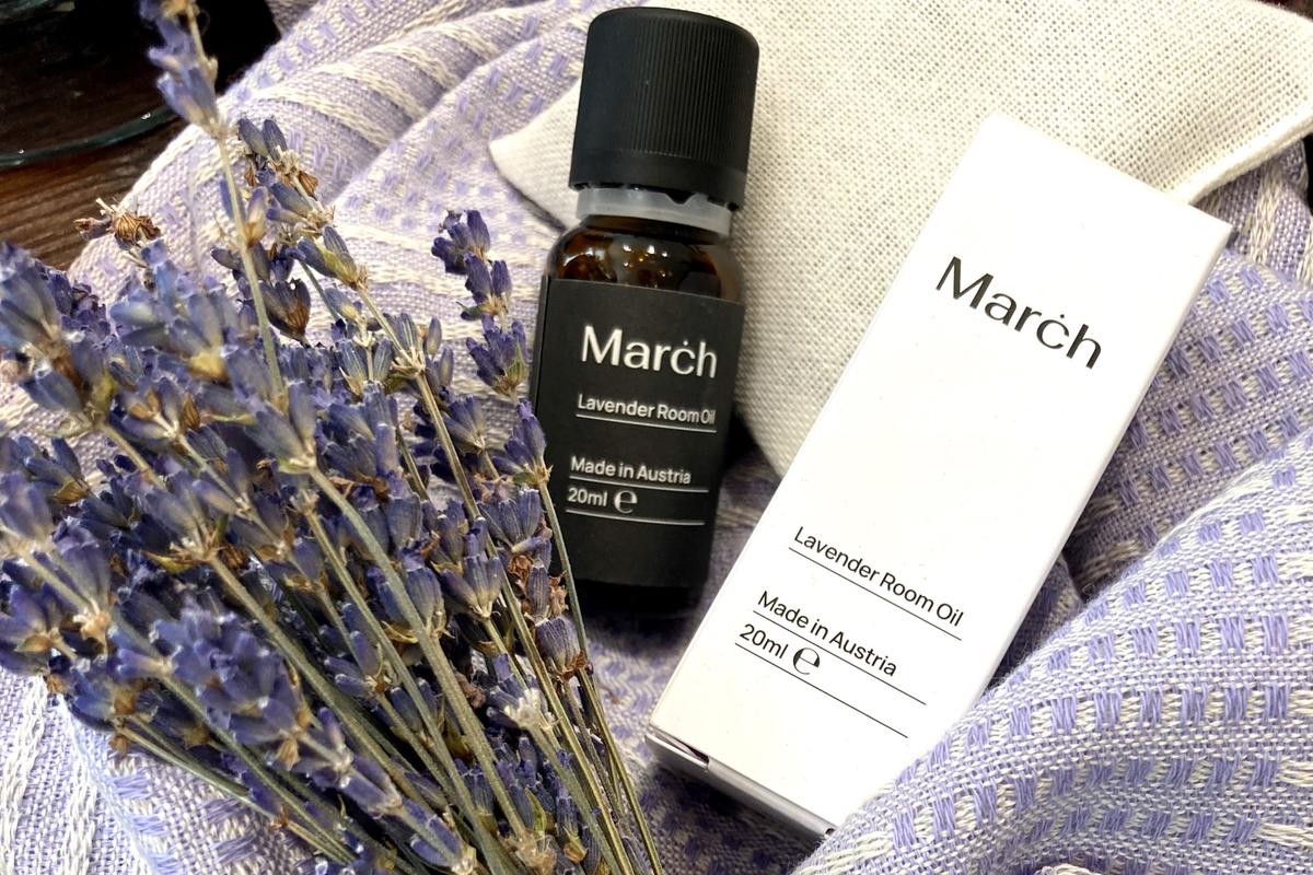 Lavendel-Öl von MARCH neben getrocknetem Lavendel auf einem lila Handtuch