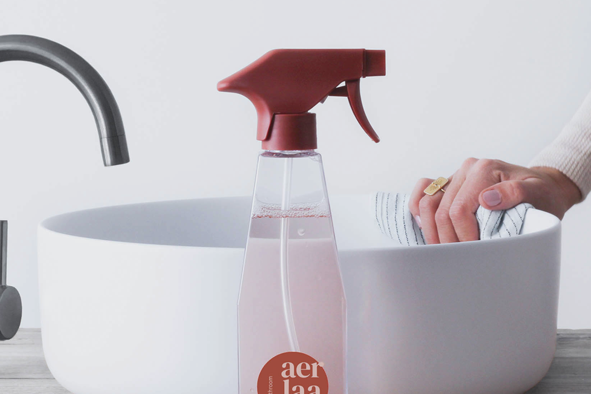 Nachfüllbarer Haushaltsreiniger von AER vor einem Waschbecken, das geputzt wird